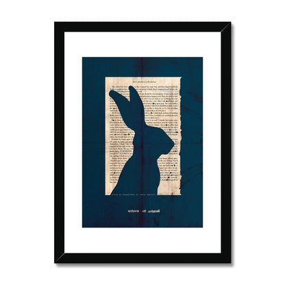 A black wooden framed fine art print showing a page from Alice in Wonderland with the silhouette of a Hare cut out on a navy blue background with the line "curiouser and curiouser" also cut out