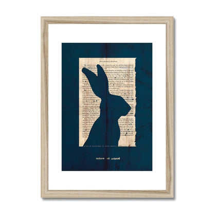 A natural wooden framed fine art print showing a page from Alice in Wonderland with the silhouette of a Hare cut out on a navy blue background with the line "curiouser and curiouser" also cut out